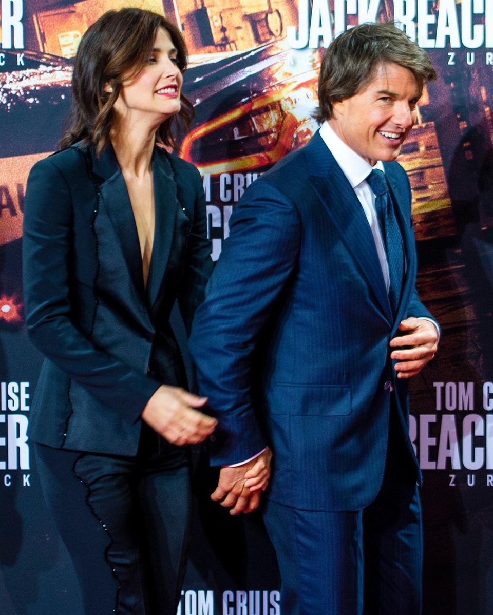 Cobie Smulders und Tom Cruise kommen Hand in Hand auf den roten Teppich.