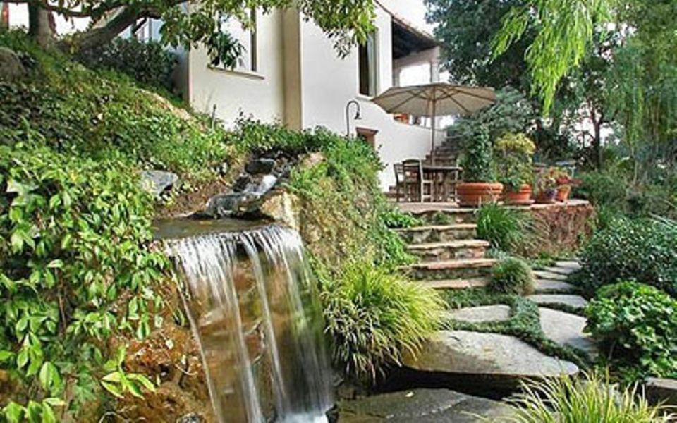 Im Garten schaffen viel Grün und ein kleiner Wasserfall eine lauschige Atmosphäre zum Entspannen. Im Garten schaffen viel Grün und ein kleiner Wasserfall eine lauschige Atmosphäre zum Entspannen.