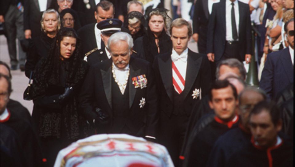 Eine Familie zerbricht. Gramgebeugt folgt Fürst Rainier am 18. September 1982 dem Sarg seiner Frau. Zur Seite stehen ihm die Kin