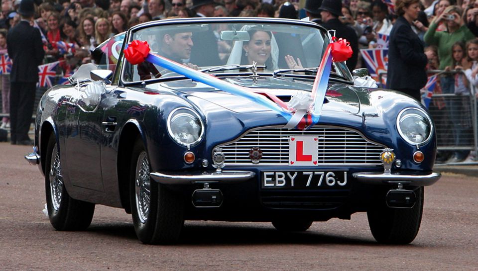 Überraschung - und die Menge jubelt: Nach dem Mittagsempfang im Buckingham
Palace braust das Brautpaar im Aston Martin davon. Überraschung - und die Menge jubelt: Nach dem Mittagsempfang im Buckingham
Palace braust das Brautpaar im Aston Martin davon.