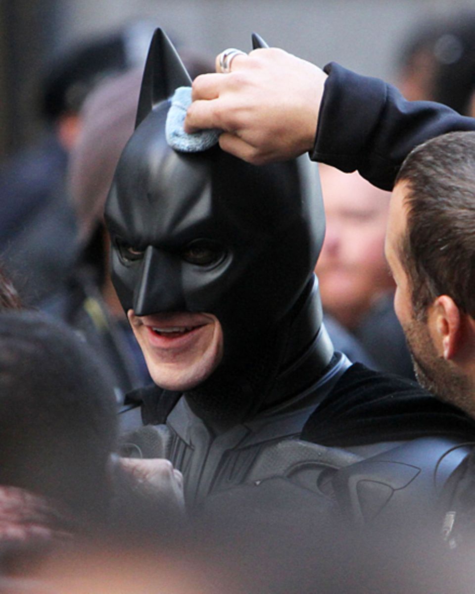 Auch Batmans Helm muss mal geputzt werden: Christian Bale lässt die Prozedur am Set in New York geduldig über sich ergehen.