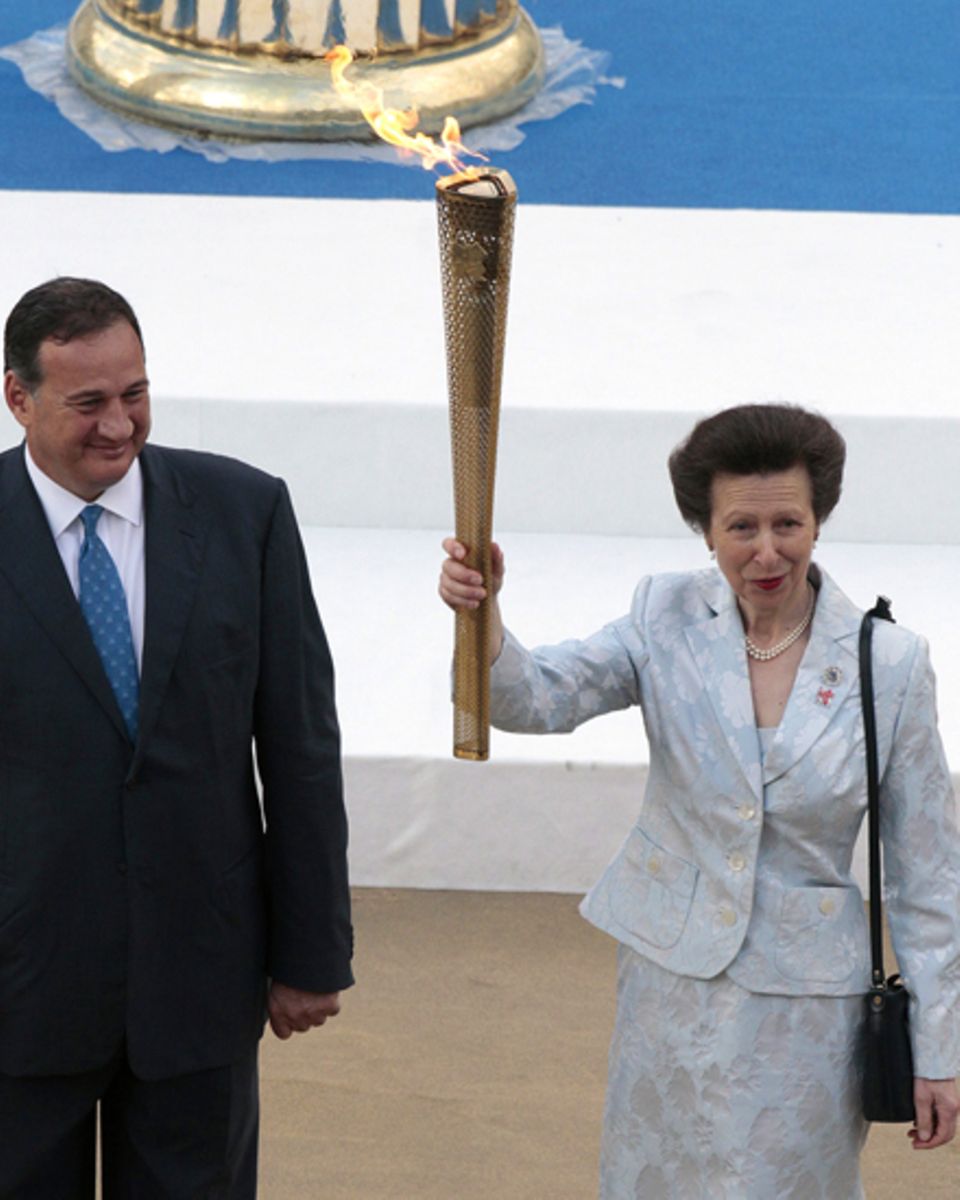 Der Vorsitzende des griechischen Olympischen Komittees, Spyros Capralos, übergibt die Flamme an Prinzessin Anne. Der Vorsitzende des griechischen Olympischen Komittees, Spyros Capralos, übergibt die Flamme an Prinzessin Anne.