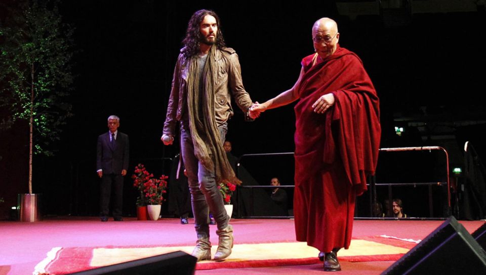 Der Dalai Lama und Russell Brand kamen Hand in Hand auf die Bühne. Der Dalai Lama und Russell Brand kamen Hand in Hand auf die Bühne.