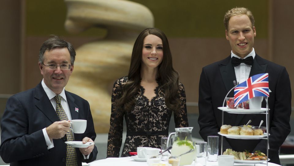 Der stellvertretende britische Botschafter Andrew Noble mit den Wachsfiguren von Kate und William in Berlin.