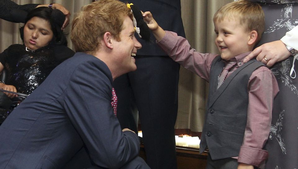 Spaß mit dem Prinzen: Der sechsjährige Alex Logan wischt mit seinem Pinguin Hookie über Harrys Stirn.