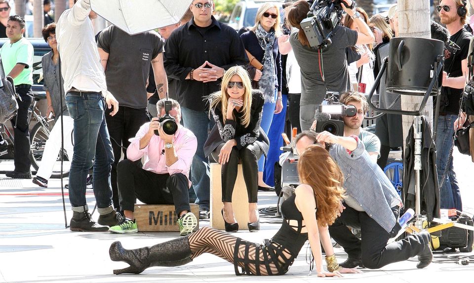 Action beim Dreh in Beverly Hills: Kandidatin Carolin rekelt sich für die Kamera des Fotografen auf dem Asphalt, "GNTM"- Jurychefin Heidi Klum verfolgt die Szene mit prüfendem Blick.