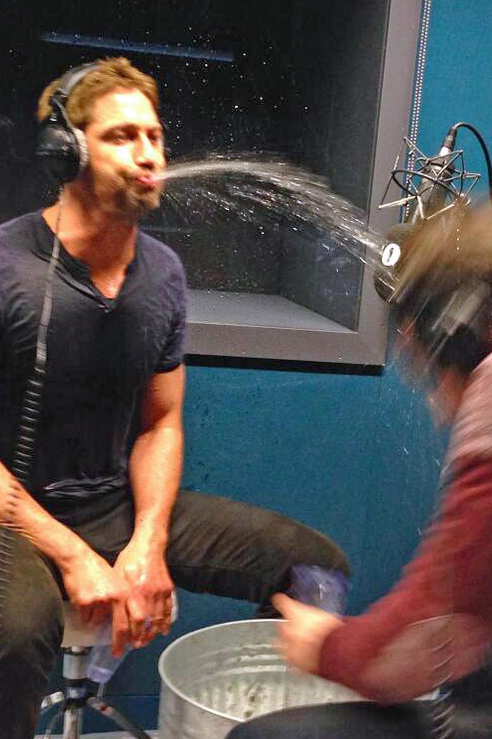 Gerard Butler bespuckt Radio-Sidekick Chris Stark mit Wasser.