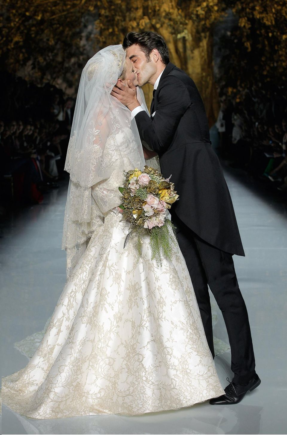 Hochzeit: Vor einem goldglänzenden Baum (und 2000 Gästen) küssen sich Braut und Bräutigam alias Model Anne V und Männermodel Jan Kortajarena. Vor einem goldglänzenden Baum (und 2000 Gästen) küssen sich Braut und Bräutigam alias Model Anne V und Männermodel Jan Kortajarena.