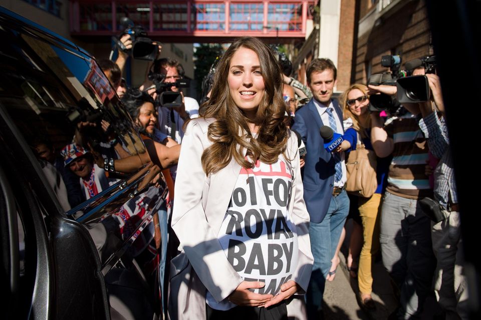 William + Catherine: Als die Kate-Doppelgängerin ihren mantel öffnete, präsentierte sie darunter das Werbeshirt ihrer Auftraggeber: "The Sun" - No. 1 for Royal Baby News" war da zu lesen. Die Zuschauer nahmen es mit Humor. Als die Kate-Doppelgängerin ihren mantel öffnete, präsentierte sie darunter das Werbeshirt ihrer Auftraggeber: "The Sun" - No. 1 for Royal Baby News" war da zu lesen. Die Zuschauer nahmen es mit Humor.