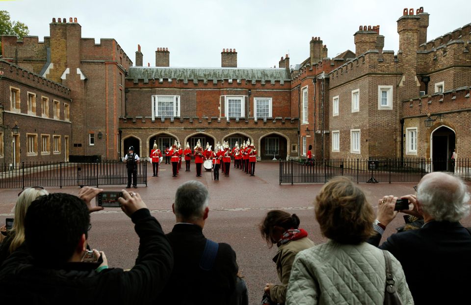 Prinz George: Vor dem "St. James Palace" haben sich trotz Londoner Nieselwetter viele Royalfans versammelt, um zu beobachten, wie die Taufgesellschaft vor der Taufe von prinz George von Cambridge an dem Stadtpalast ankommt. Vor dem "St. James Palace" haben sich trotz Londoner Nieselwetter viele Royalfans versammelt, um zu beobachten, wie die Taufgesellschaft vor der Taufe von prinz George von Cambridge an dem Stadtpalast ankommt.