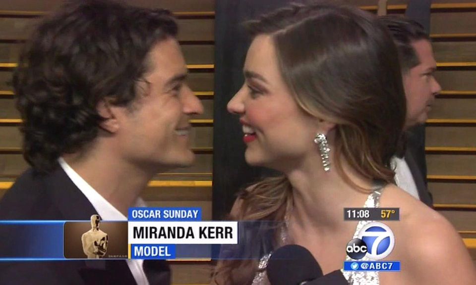 Orlando Bloom überrascht Miranda Kerr während eines Interviews.