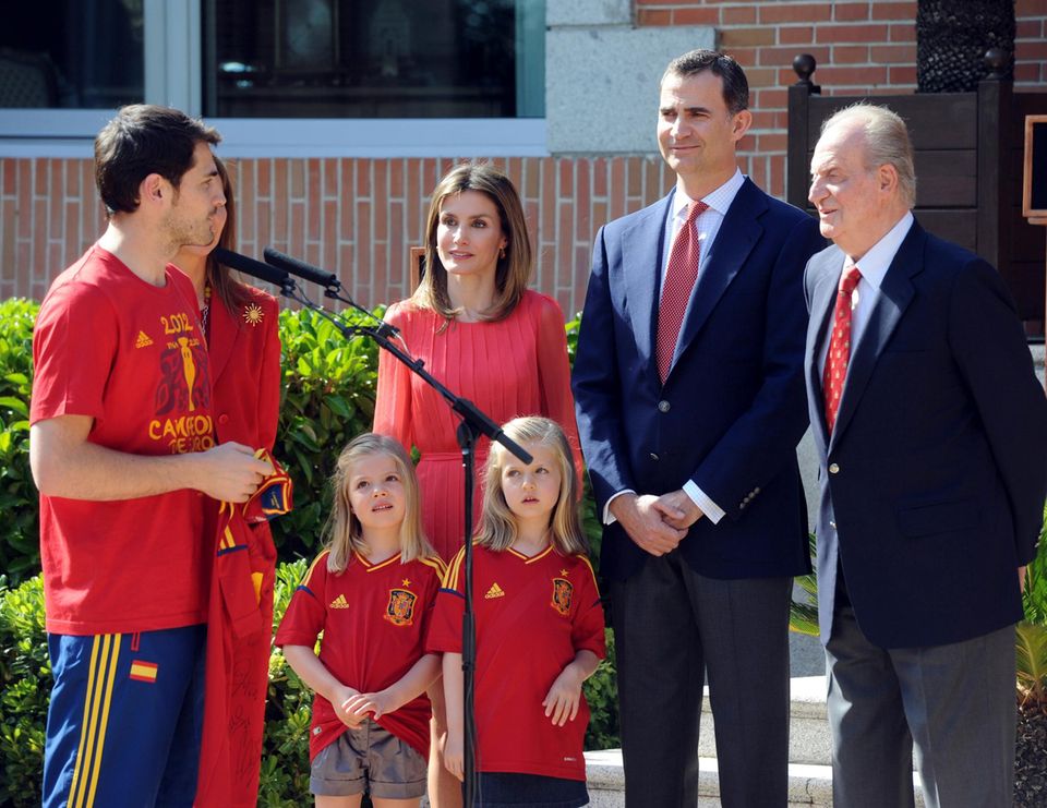 Auftritte wie dieser waren bisher selten: Gemeinsam mit ihren Eltern und ihrem Großvater sind die Prinzessinnen Sofía (links) und Leonor im Juli 2012 beim Empfang der spanischen Fußballnationalmannschaft dabei.