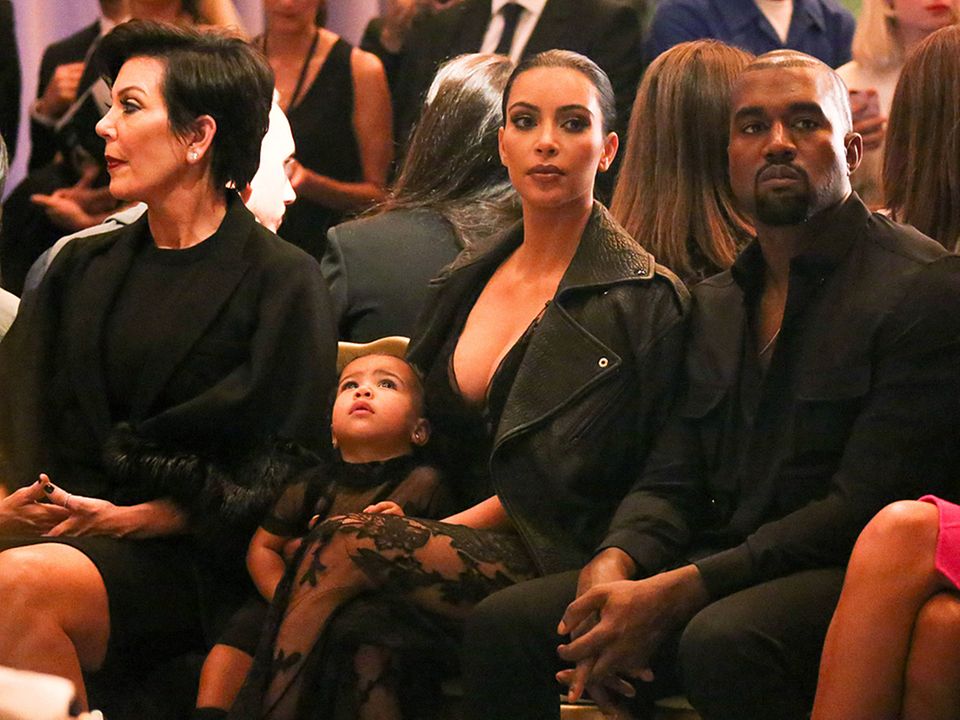 Während Mama Kim Kardashian (Mi.), Papa Kanye West (re.) und Oma Kris Jenner (li.) gespannt der Givenchy-Fashion-Show folgen, wirkt ihre kleine North West eher abwesend und verträumt.