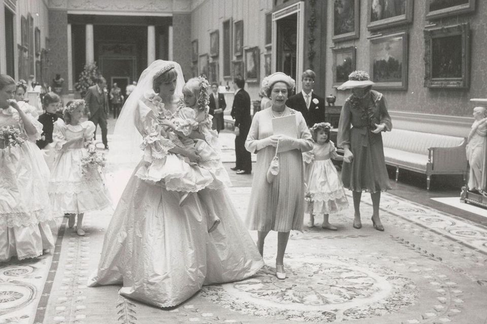 Prinzessin Diana: Prinzessin Diana trägt eines ihrer Blumenmädchen auf dem Arm und spricht ihr Mut zu Prinzessin Diana trägt eines ihrer Blumenmädchen auf dem Arm und spricht ihr Mut zu