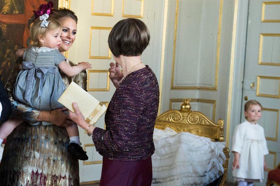 Im Hintergrund schaut Prinzessin Estelle zu, wie Prinzessin Madeleine, Chris O'Neill und (nicht im Bild) König Carl Gustaf und Königin Silvia die Glückwünsche entgegen nehmen. Cousine Leonore ist ebenfalls dabei.