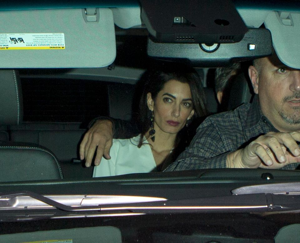 Während George Clooney die Nähe zu seiner Ehefrau und seinen Arm behutsam um Amal legt, wirkt diese auf der Rücksitzbank eher muffelig statt kuschelig.