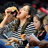 Wie es sich zu einem spannenden Basketballspiel gehört, isst Jennifer Garner genüsslich ein Stück Pizza und fiebert in der Halle mit.