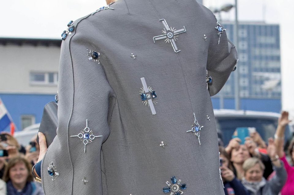 Königin Máxima: Schmucksteine, Schrauben und Nägel zieren den Mantel von Königin Máxima. Wer will, kann in einigen Elementen Anlehnungen an das Hakenkreuz-Symbol erkennen. Schmucksteine, Schrauben und Nägel zieren den Mantel von Königin Máxima. Wer will, kann in einigen Elementen Anlehnungen an das Hakenkreuz-Symbol erkennen.