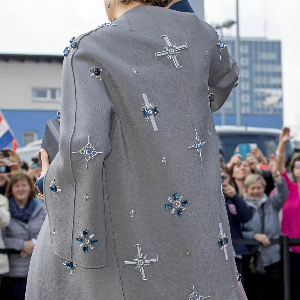Schmucksteine, Schrauben und Nägel zieren den Mantel von Königin Máxima. Wer will, kann in einigen Elementen Anlehnungen an das Hakenkreuz-Symbol erkennen.