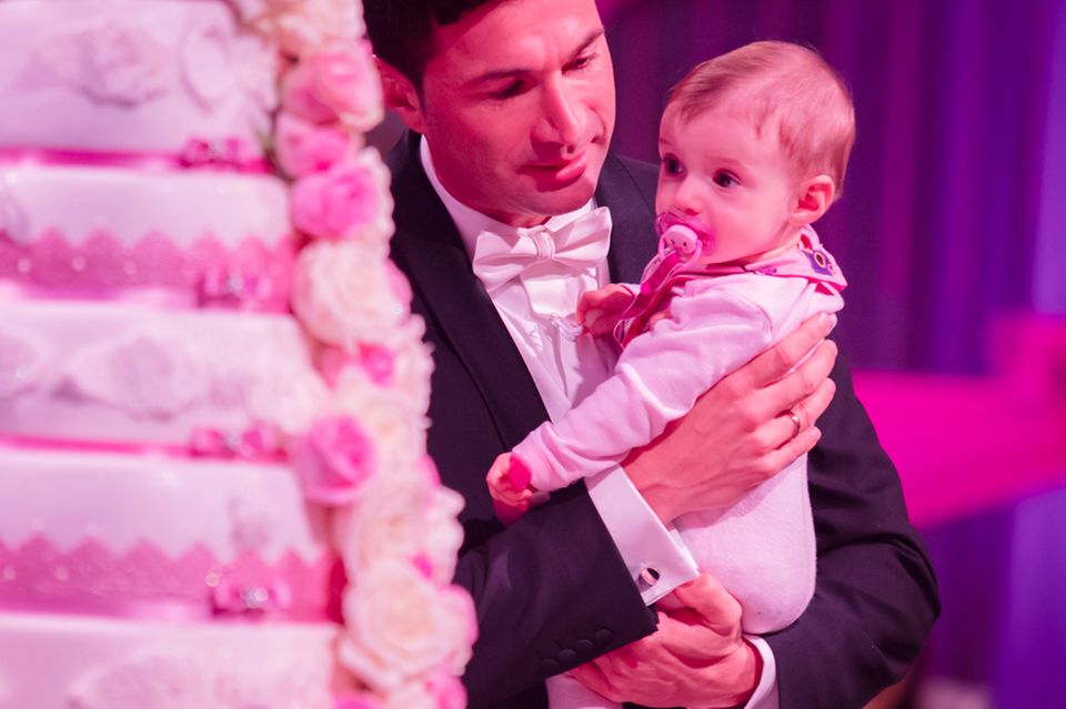 Gemeinsam mit Papa Lucas bestaunt die kleine Sophia die pinke Hochzeitstorte.
