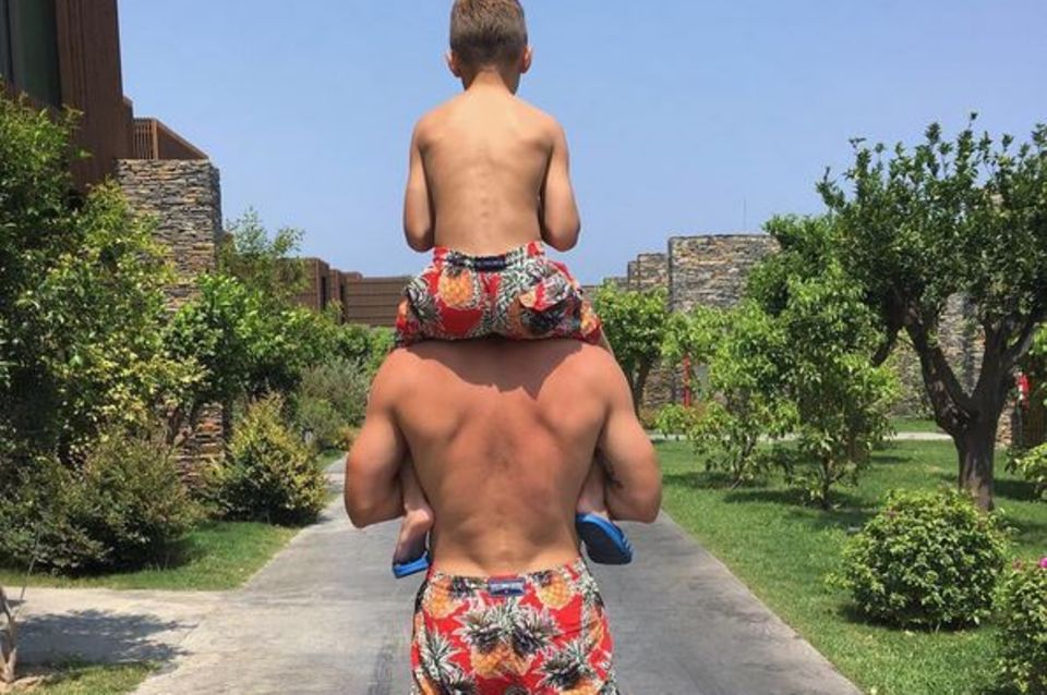 Lukas Podolski trägt Sohn Lois auf den Schultern: Sehr trendig sind auch die Ananas-Badehosen im Partnerlook.