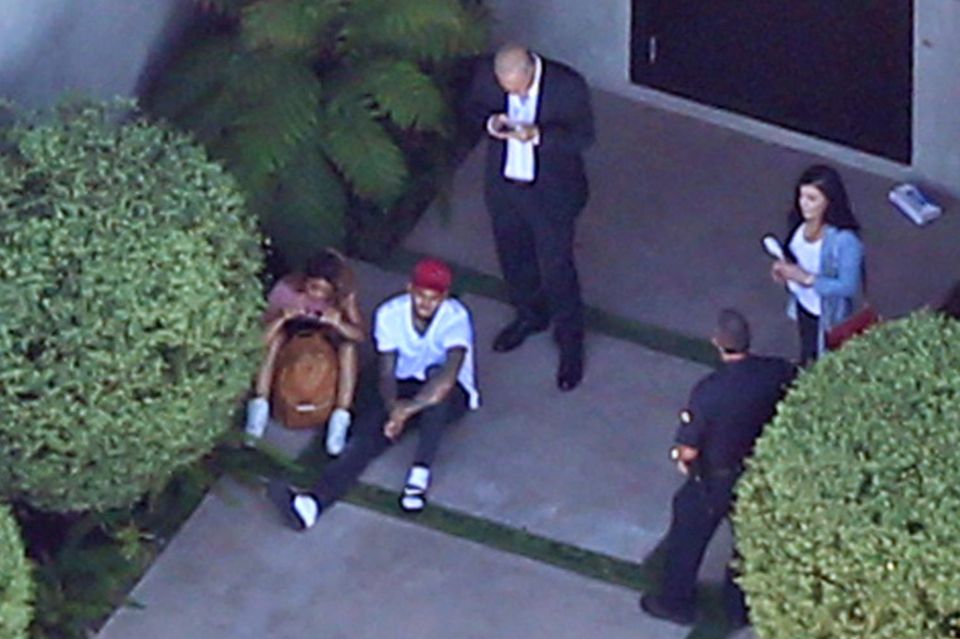 Chris Brown sitzt entspannt mit seiner Entourage vor dem Haus und wartet.