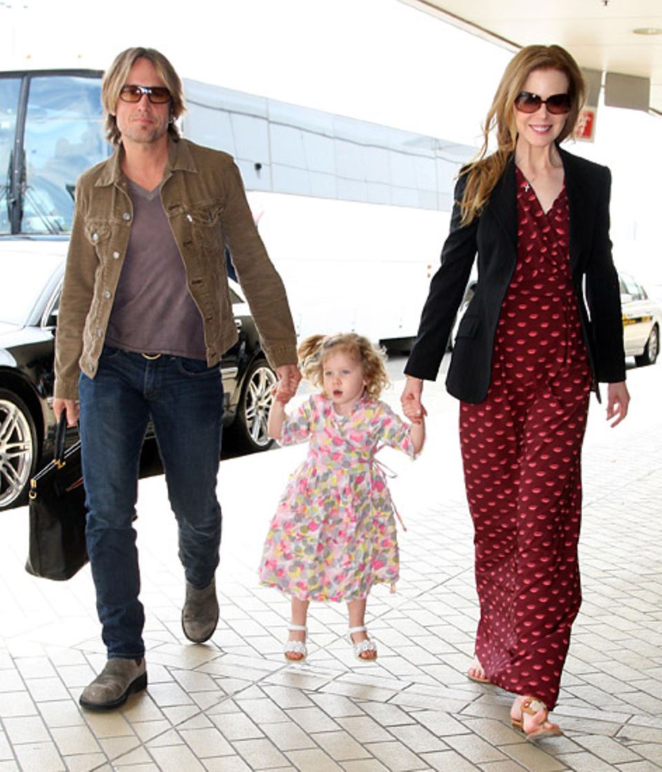 23. Dezember 2010: Keith Urban und Nicole Kidman nehmen ihre Tochter Sunday Rose am Flughafen in Sydney in ihre Mitte.