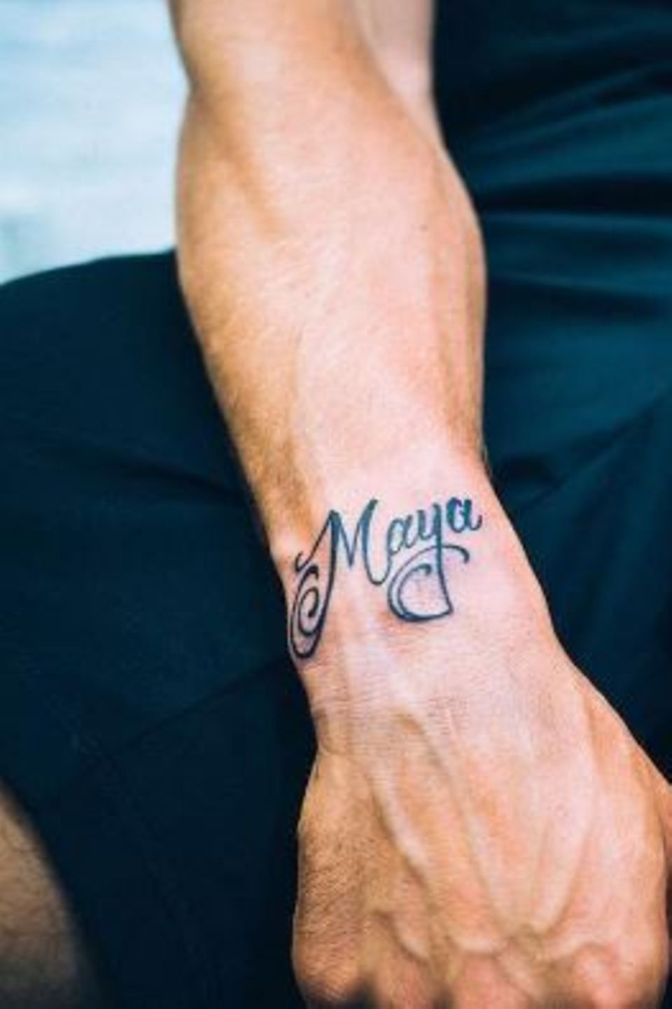 Stolz präsentiert Lukas Podolski seine neuesten Tattoos am Handgelenk, rechts der Name seiner Tochter Maya und links die Spielernummer.