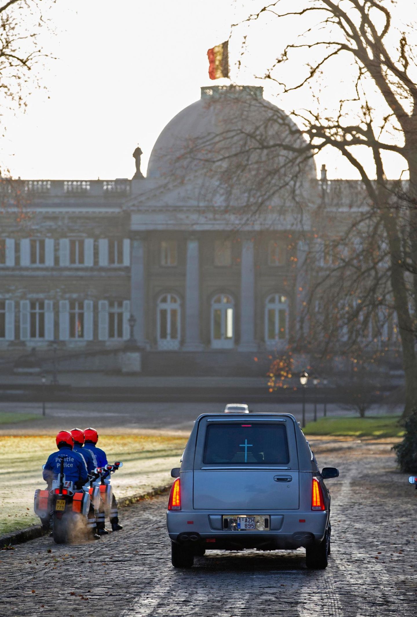 8. Dezember 2014: Königin Fabiolas Sarg wird mit Polizeiteskorte nach Schloss Laeken überführt. Die belgische Fahne auf dem Schloss weht seit dem Tod der Königin bereits auf Halbmast.