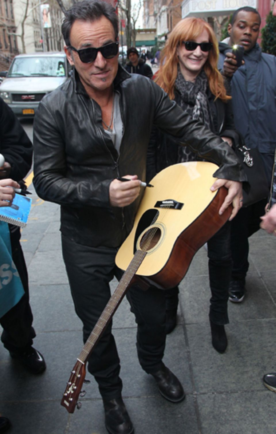 Gerne gibt Bruce Springsteen ein Autogramm auf einer Gitarre.