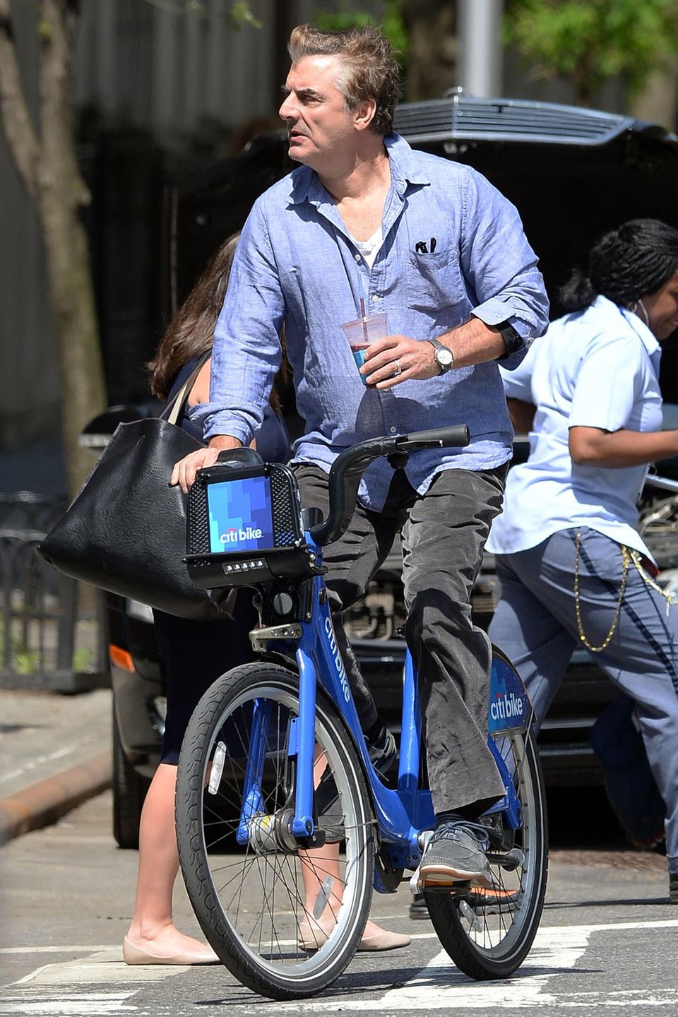 Mit einer Hand lenkt Chris Noth sein Citibike durch Manhattan, in der anderen transportiert er ein erfrischendes Kaltgetränk.