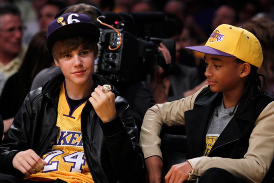 Justin Bieber ballt die Faust und bejubelt das Basketballteam der L.A. Lakers. Jaden Smith schaut auf den großen Ring am Finger Justin Bieber ballt die Faust und bejubelt das Basketballteam der L.A. Lakers. Jaden Smith schaut auf den großen Ring am Finger
