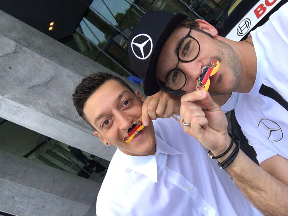 Mesut Özil und der deutsche Rennfahrer Maximilian Götz setzen sich mit dem schwarz-rot-goldenden Moustache für den guten Zweck ein. Es geht um Freundschaft, Solidarität und Faiplay.