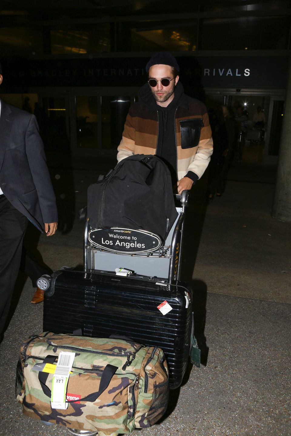Robert Pattinson kommt am Flughafen LAX in Los Angeles an. Sein Gepäck schiebt er lieber selbst.