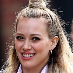 Hilary Duff muss sich dank neues Frisuren-Trends nicht mehr zwischen Zopf und offenem Haar entscheiden. Für den Half-up-Dutt steckt sie ihr Deckhaar hoch und legt ihre leichten Wellen nach vorne über die Schultern.
