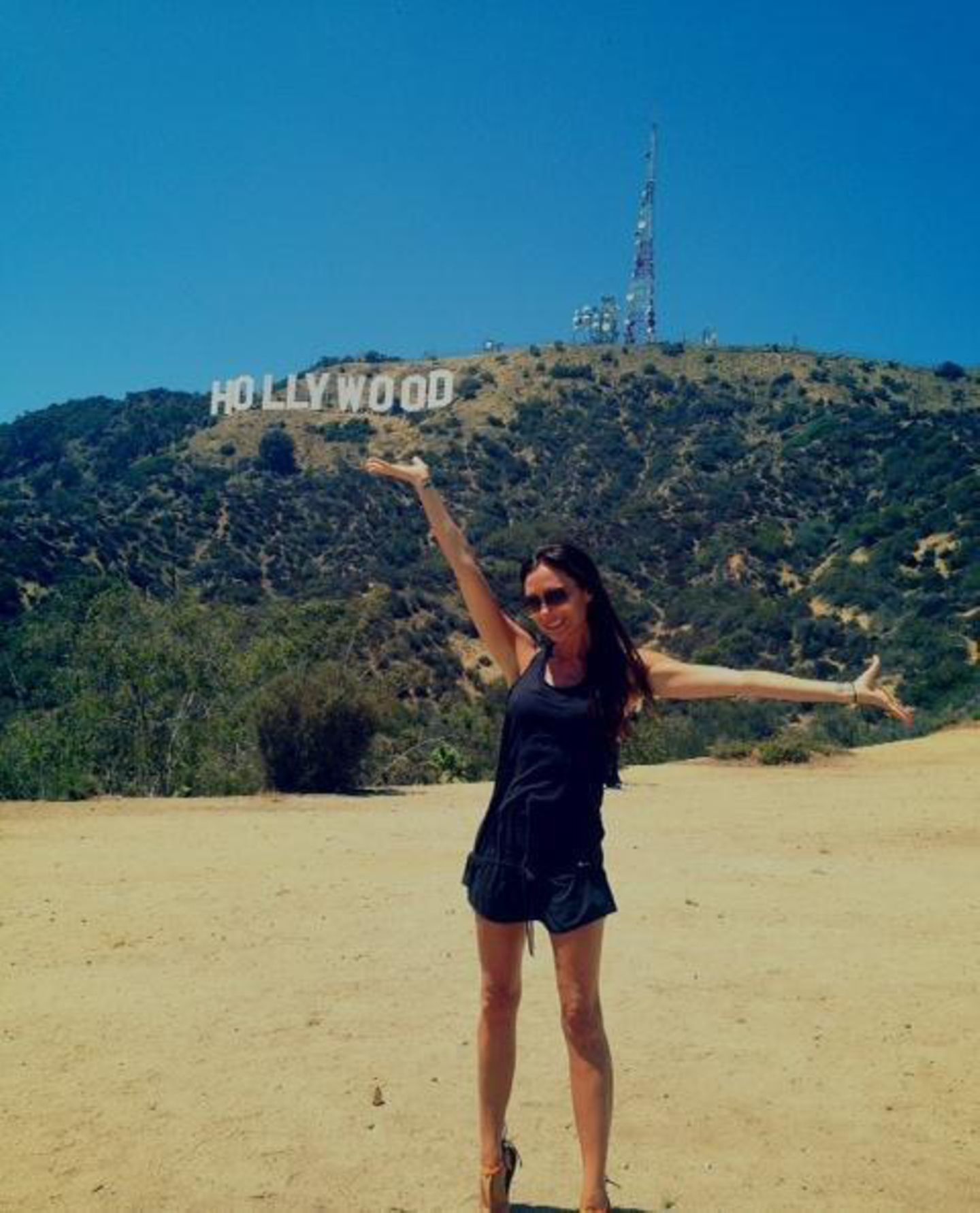 Ungewöhnlich glücklich zeigt sich Victoria Beckham vor dem Hollywood-Sign.