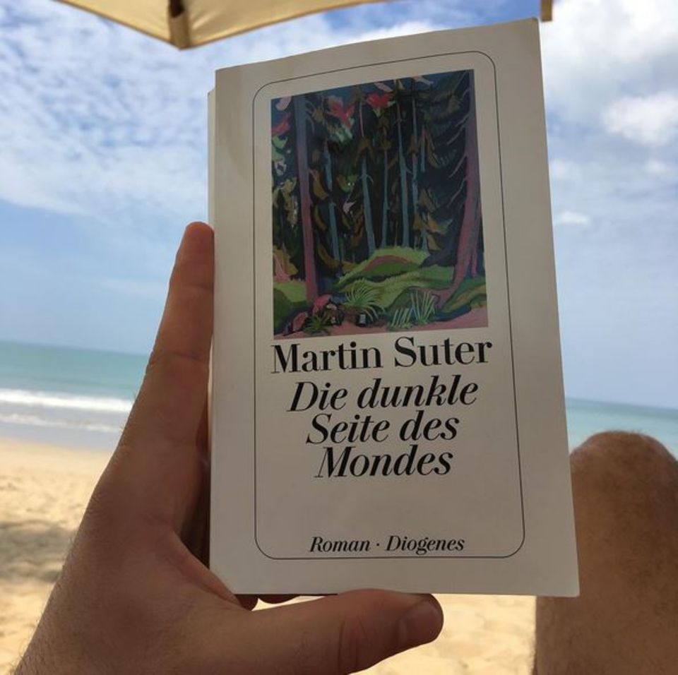 Unter der Sonne liest Elyas M'Barek das Buch "Die dunkle Seite des Mondes" von Martin Suter und spricht eine deutliche Empfehlung aus.