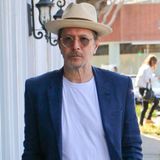 Sommerlich-maritim mit weißen Jeans, T-Shirt, blauem Sakko und Bast-Fedora zieht Gary Oldman durch die Nachbarschaft von West Hollywood.