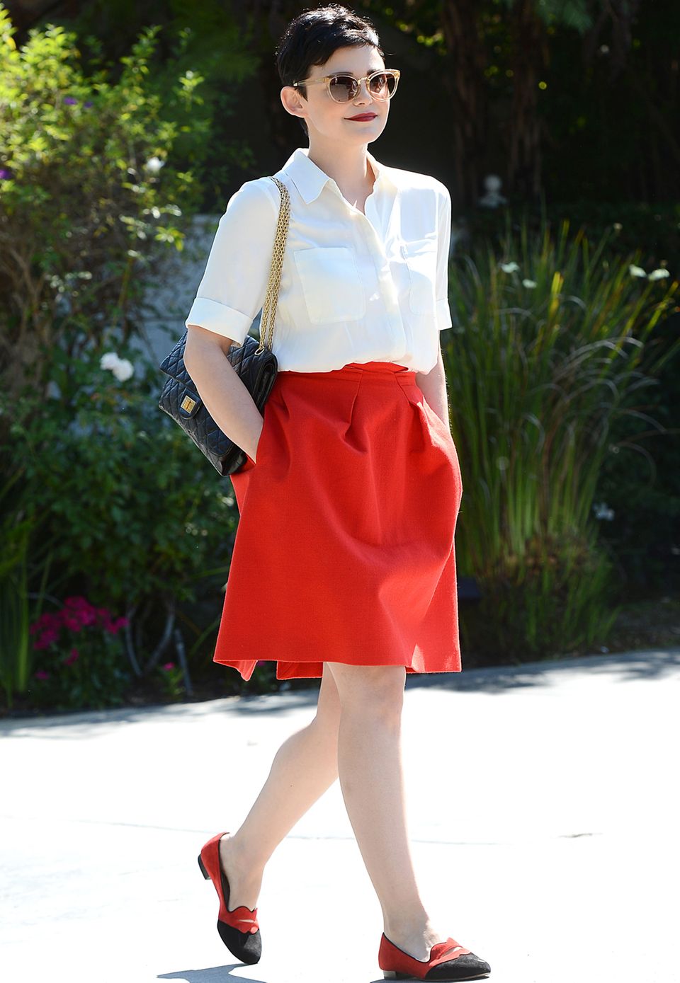 Für eine Gartenparty in Hollywood greift Ginnifer Goodwin auf eine schlichte weiße Bluse, einen roten, ausgestellten Rock und bequeme Slipper zurück.