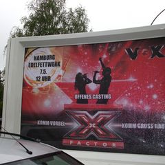 Ein Schild am Wegesrand deutet bereits auf das offene Casting von X Factor in Hamburg hin.