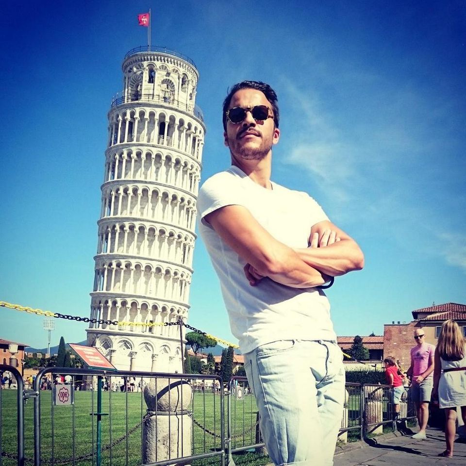 Ganz schön lässig! Kostja Ullmann lehnt sich an den schiefen Turm von Pisa. Er ist gerade in Italien unterwegs und teilt seine Erlebnisse mit seinen Twitter-Fans.