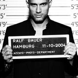 Raspelkurzes Haar und verwegener Blick: Ralf Bauer hält sein Schild in die Kamera.