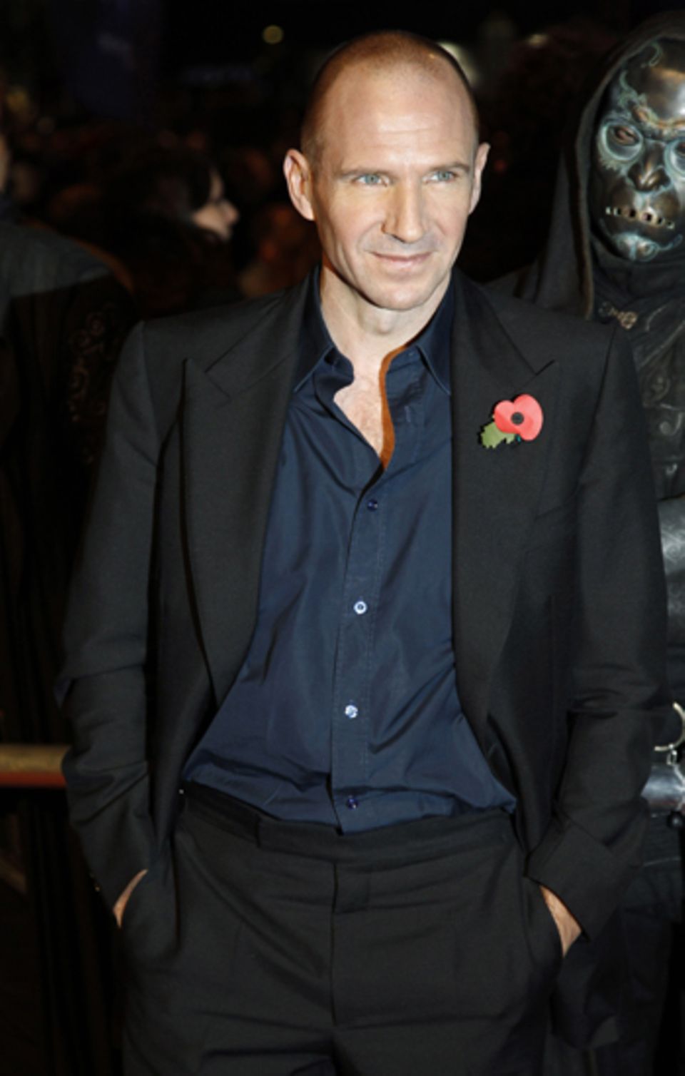 Ralph Fiennes stellt sich lässig mit den Händen in der Hose vor die Kameras.