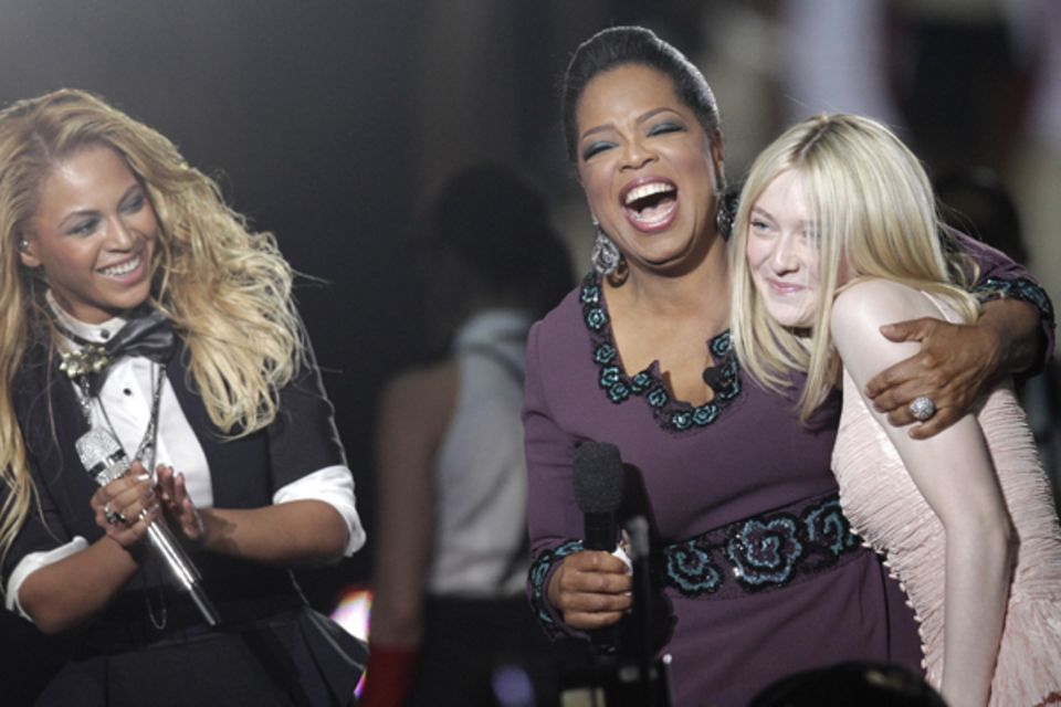 Die Stimmung könnte besser nicht sein: Freudestrahlend nimmt Oprah Winfrey Dakota Fanning in ihren Arm.