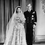 Norman Hartnell entwarf 1947 für Prinzessin Elizabeth, die spätere Queen, ein Kleid aus weißem Satin mit einem hohen Kragen.