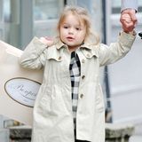 Shoppen mit Papa David findet die kleine Harper Beckham jetzt schon toll, und ihre Tüte trägt sie natürlich selbst. Im Mini-Trenchcoat und kariertem Kleid sieht sie dabei auch ganz besonders lässig aus.