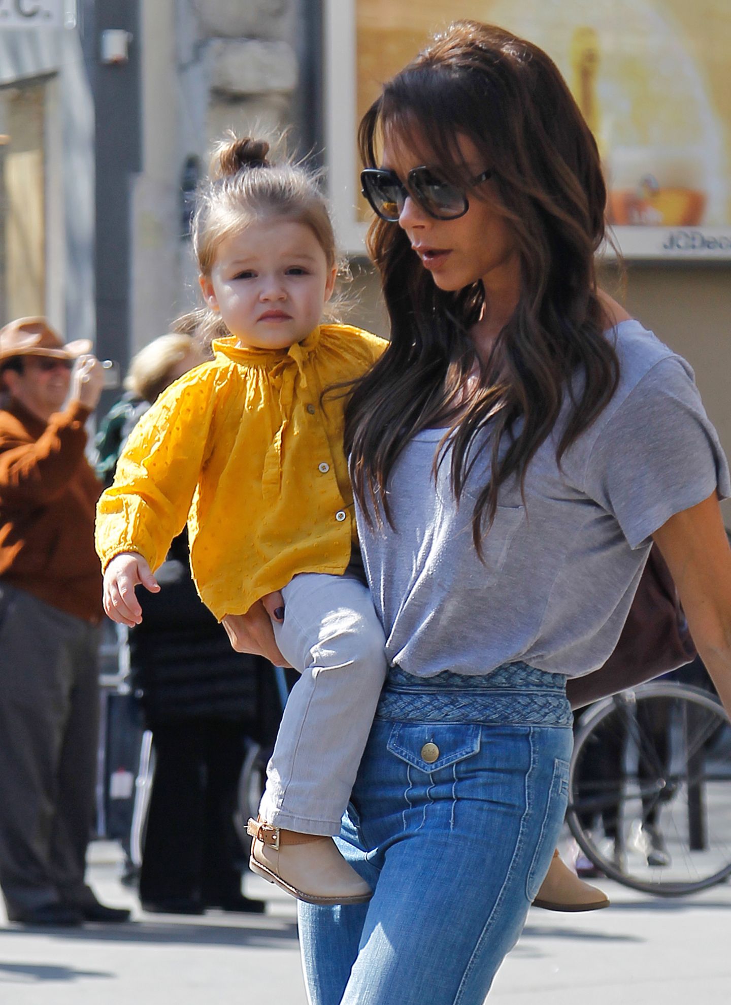Wie eine kleine Sonne leuchtet Harper in der gelben Leinenbluse. Passend lässig dazu Mama Victorias T-Shirt-Jeans-Look.