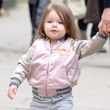 18. März 2013: Geschnürte Gummistiefel von Marc Jacobs und eine rosafarbene Bomberjacke von Stella McCartney: So lässig gestylt spaziert Harper an der Hand von Papa David Beckham durch London.