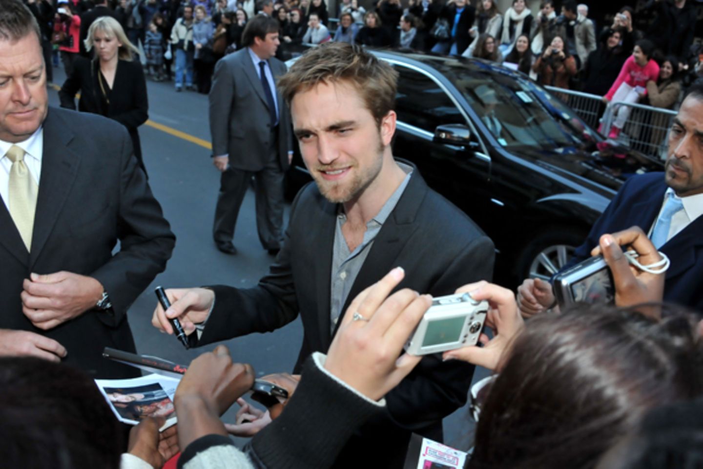 Wenige Wochen vor dem Start von "Breaking Dawn" schreibt Robert Pattinson in Paris fleißig Autogramme.