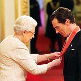 Queen Elizabeth steckt Benedict Cumberbatch den Orden "Commander of The British Empire" an.